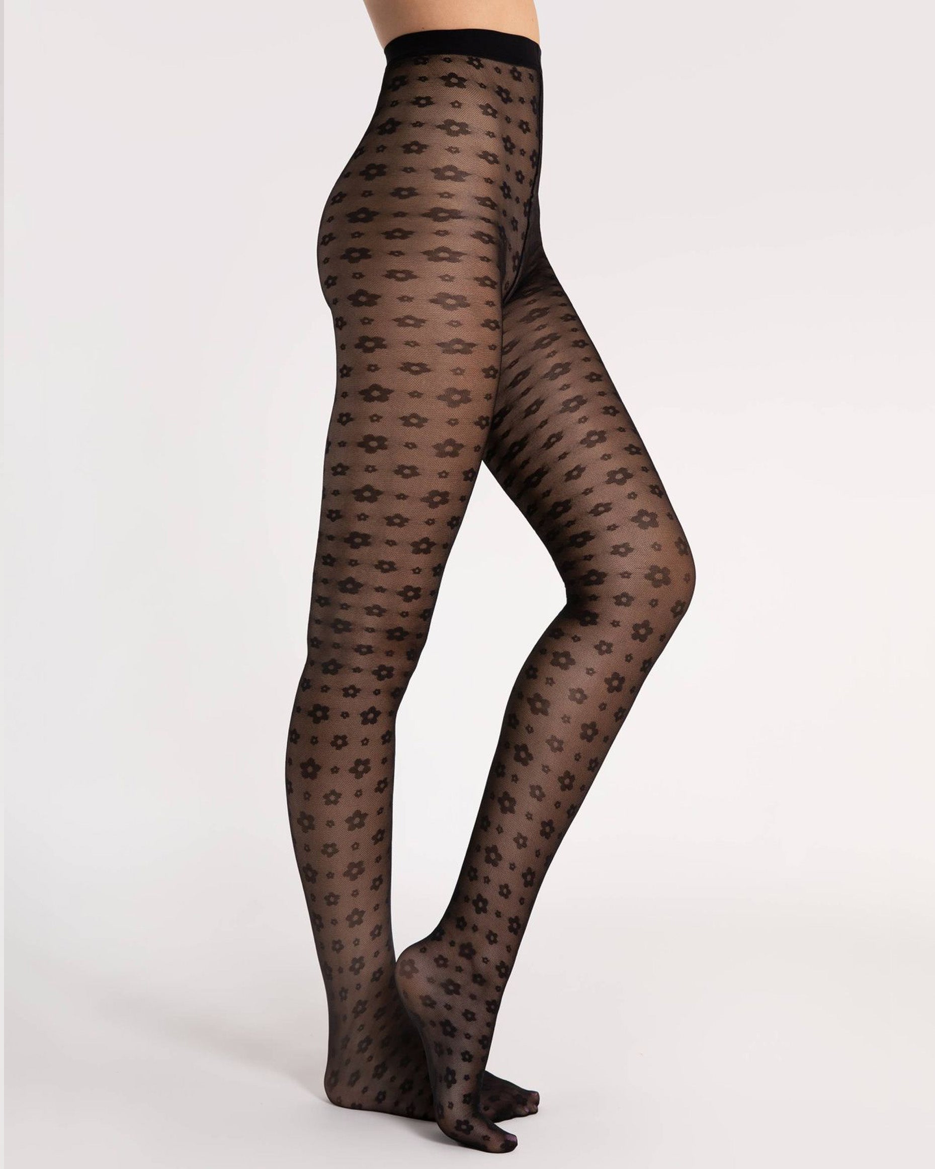 Fiore Footloose Tights - Sheer black micro mesh fashion tights with an all over woven small daisy style flower pattern. Side view.