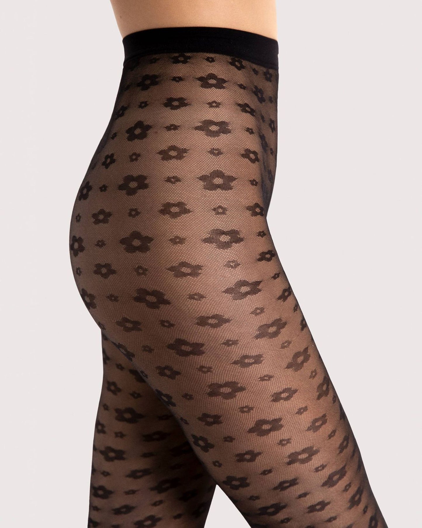 Fiore Footloose Tights - Sheer black micro mesh fashion tights with an all over woven small daisy style flower pattern. Close up detail.