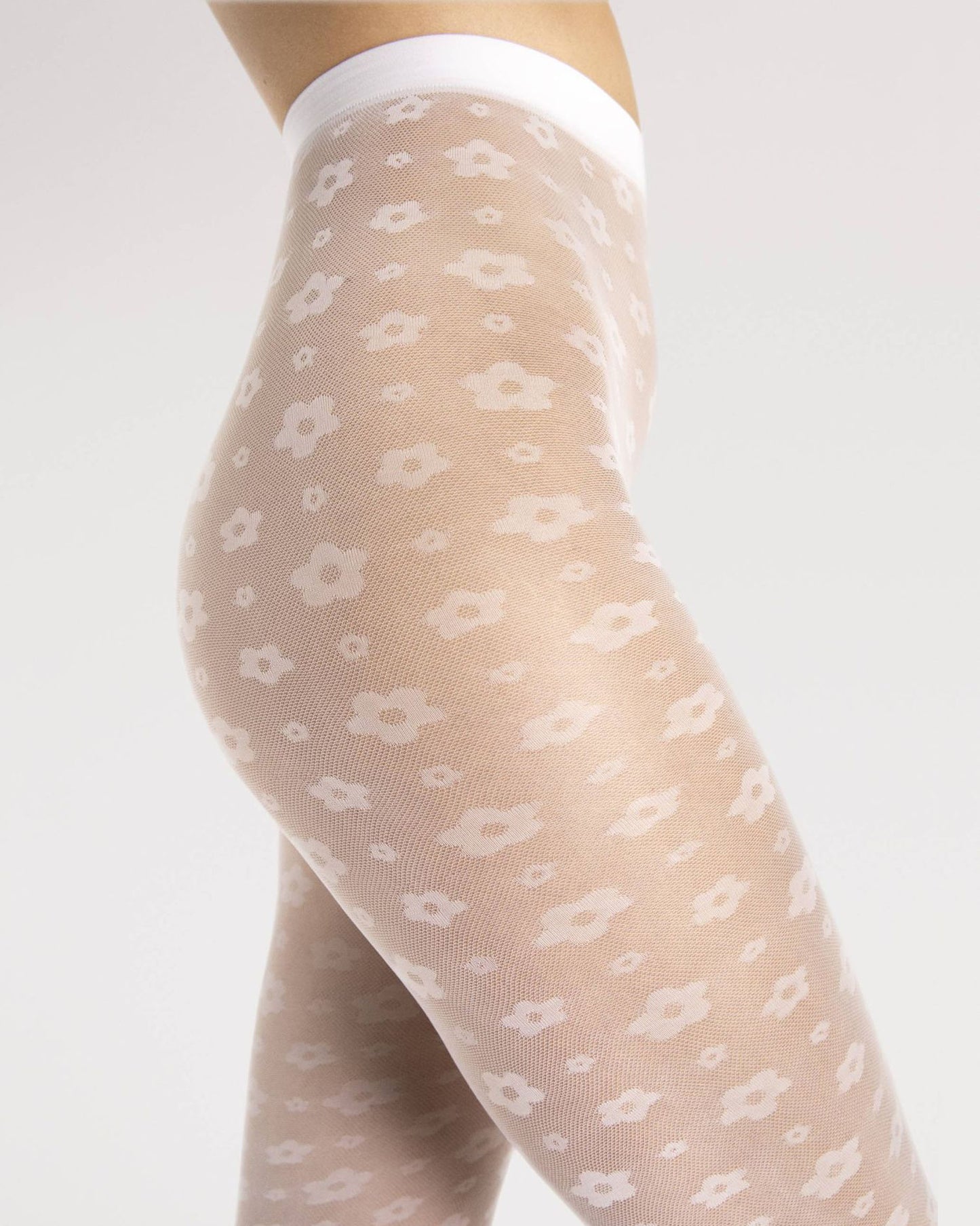 Fiore Footloose Tights - Sheer white micro mesh fashion tights with an all over woven small daisy style flower pattern. Close up detail.