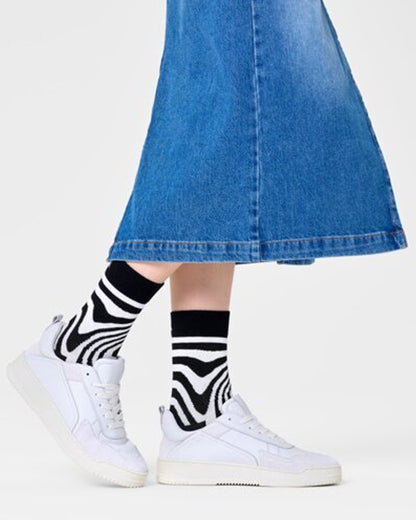 Happy Socks P000737 Dizzy Socks - Black cotton crew length ankle socks with a swirling psychedelic style linear pattern in white. Worn with denim skirt and white trainers.