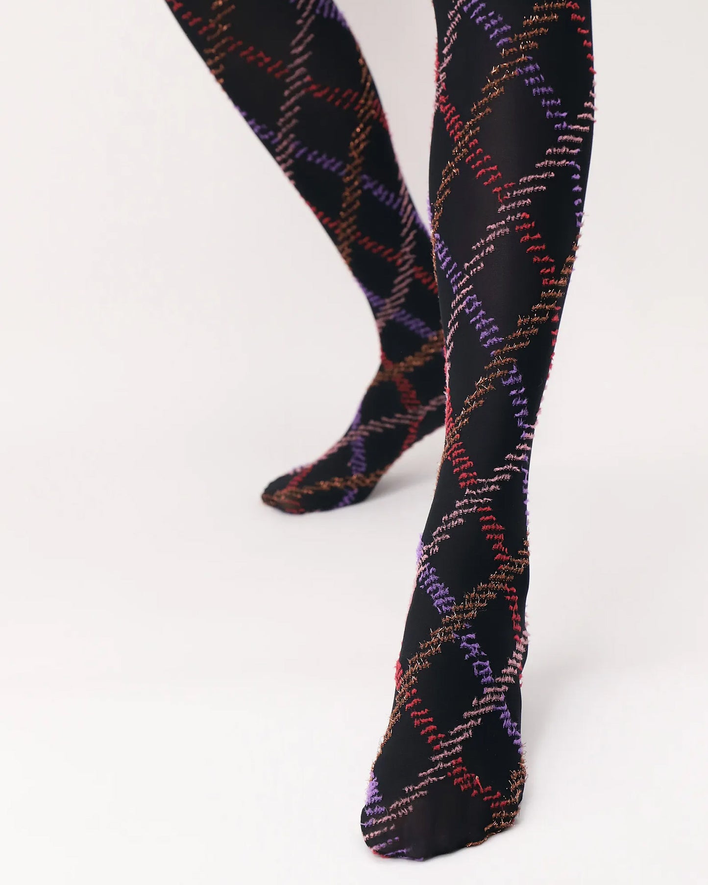 Oroblù Fur Tartan Tights - Black opaque fashion tights with a textured diamond tartan style pattern in purple, red, pale pink and gold. Close up of foot and chin.