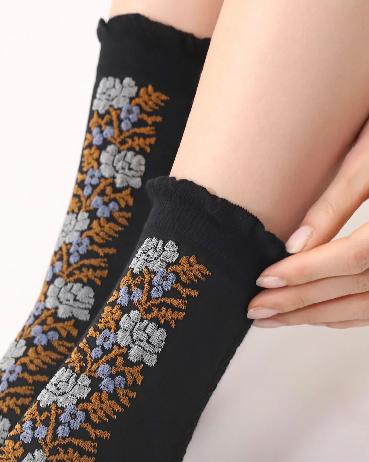 Oroblù Floral Line Sock - Black cotton ankle socks with a floral stripe panel on the front in rust, light grey and blue with a frill cuff. Close up.