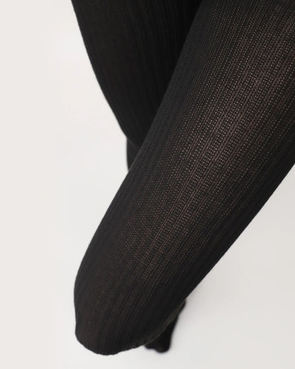 Oroblu Eco Natural Rib Tights - Black ribbed knitted tights made of soft recycled polyester and viscose. Close up of thigh and knee.