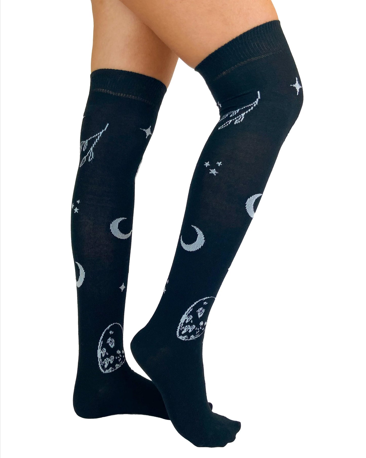 Pamela Mann Astrology Over-Knee Socks - Black cotton otk socks with an all over astrology themed pattern of moons, stars, planets and pointing hands in off white with a deep elasticated cuff. Side view.