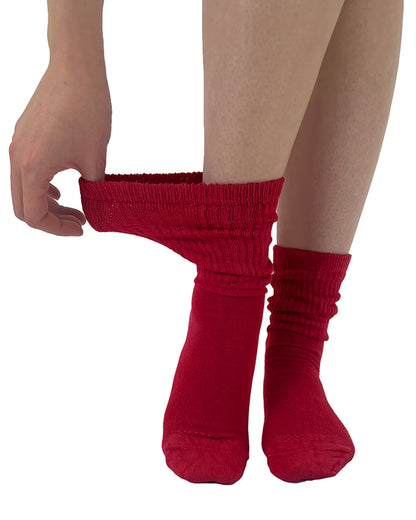 Soft and breathable red bamboo slouch socks with a loose knitted rib top, ankle and foot support and flat toe seams. Model is pulling cuff to show how stretchy they are.