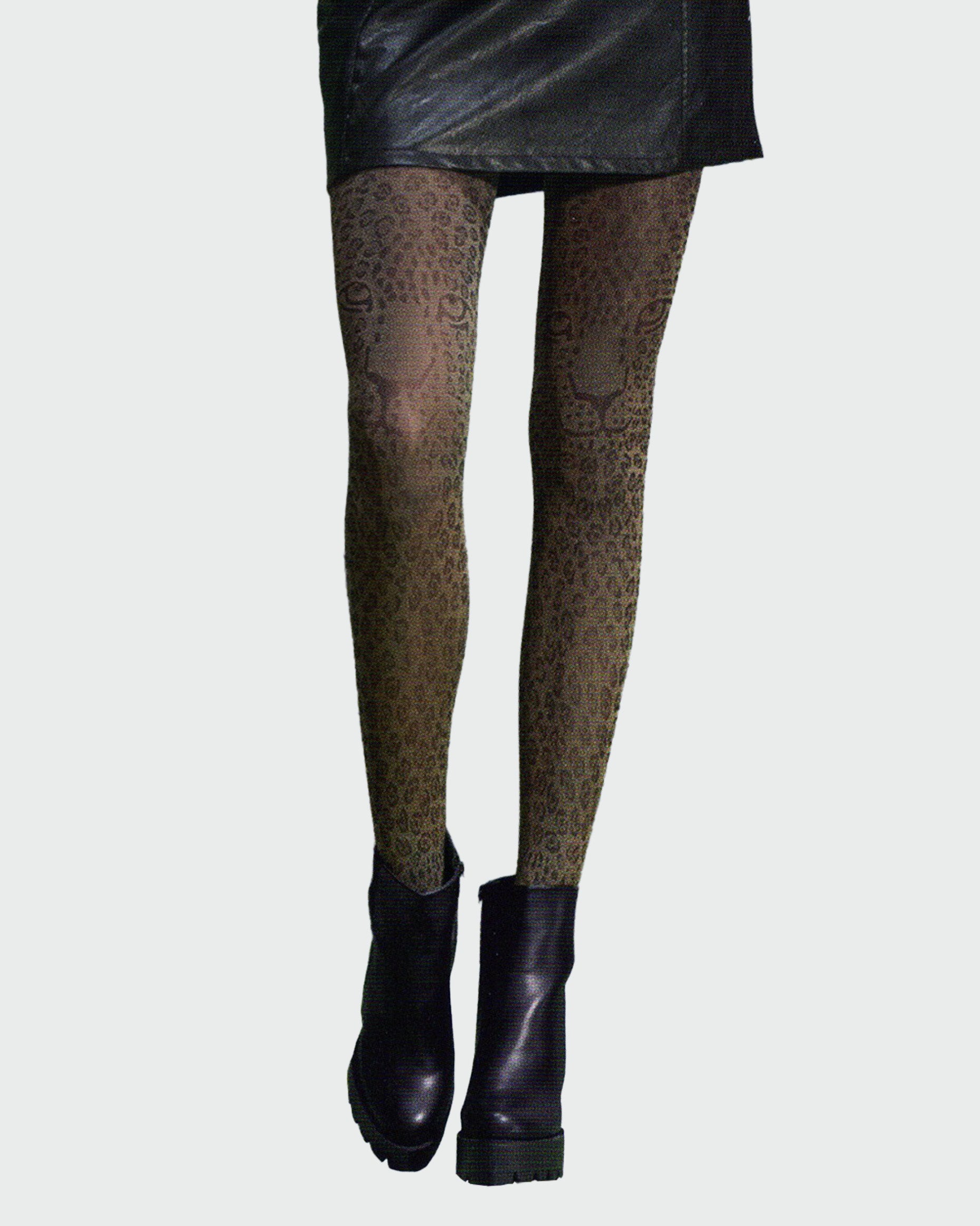 Silvia Grandi The Beast Collant - Beige opaque fashion tights with a woven black leopard print pattern with leopard faces above the knee, worn with black leather mini skirt and black ankle boots.