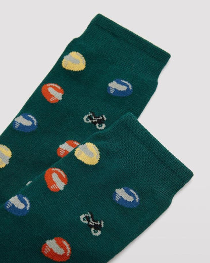 Ysabel Mora 22154 Motorbike Sock - Men's green cotton crew length ankle socks with an all over pattern of multicoloured motor cycling helmets and motorbikes with soft anti-pressure cuffs. Close up detail.