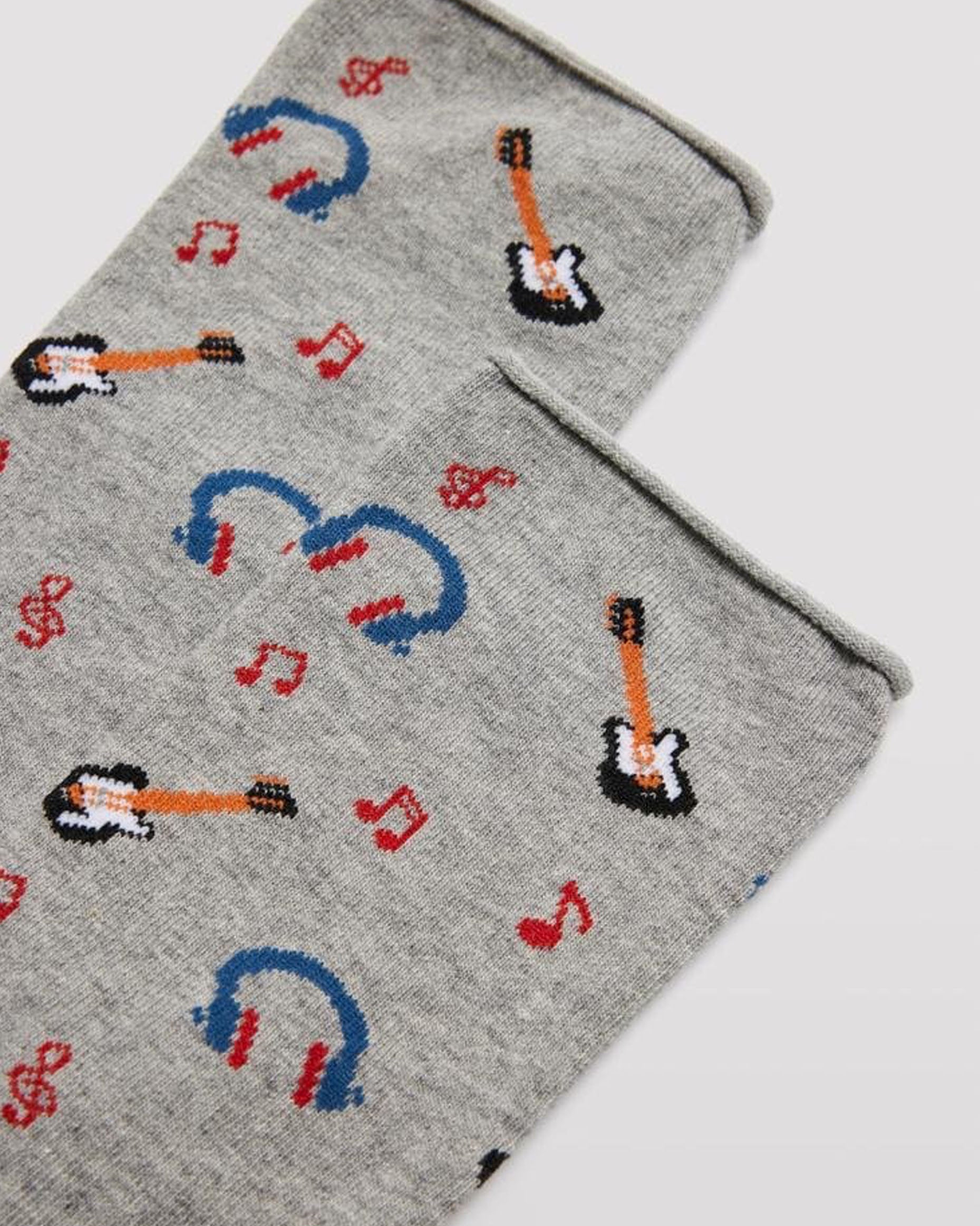 Ysabel Mora 22160 Music Sock  Light grey men's cotton crew ankle socks with an all over music themed pattern of musical notes, electric guitars and headphones with no cuff roll top anti-pressure edge. Close up detail.