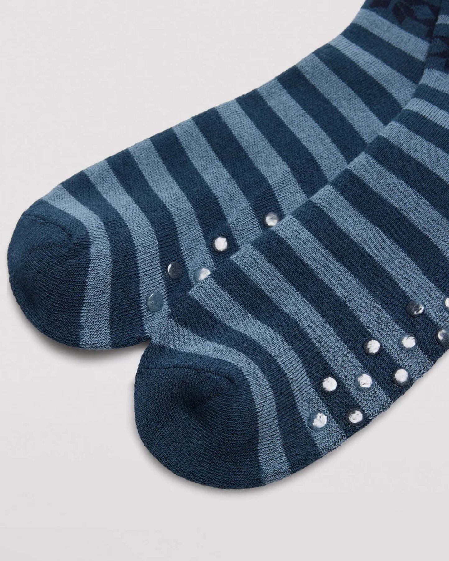 Ysabel Mora 22167 Snowflake Slipper Socks - Men's cotton crew length cotton ankle socks with a horizontal pattern of snowflakes and stripes in shades of blue and navy, dotted non-slip gripper sole detail.