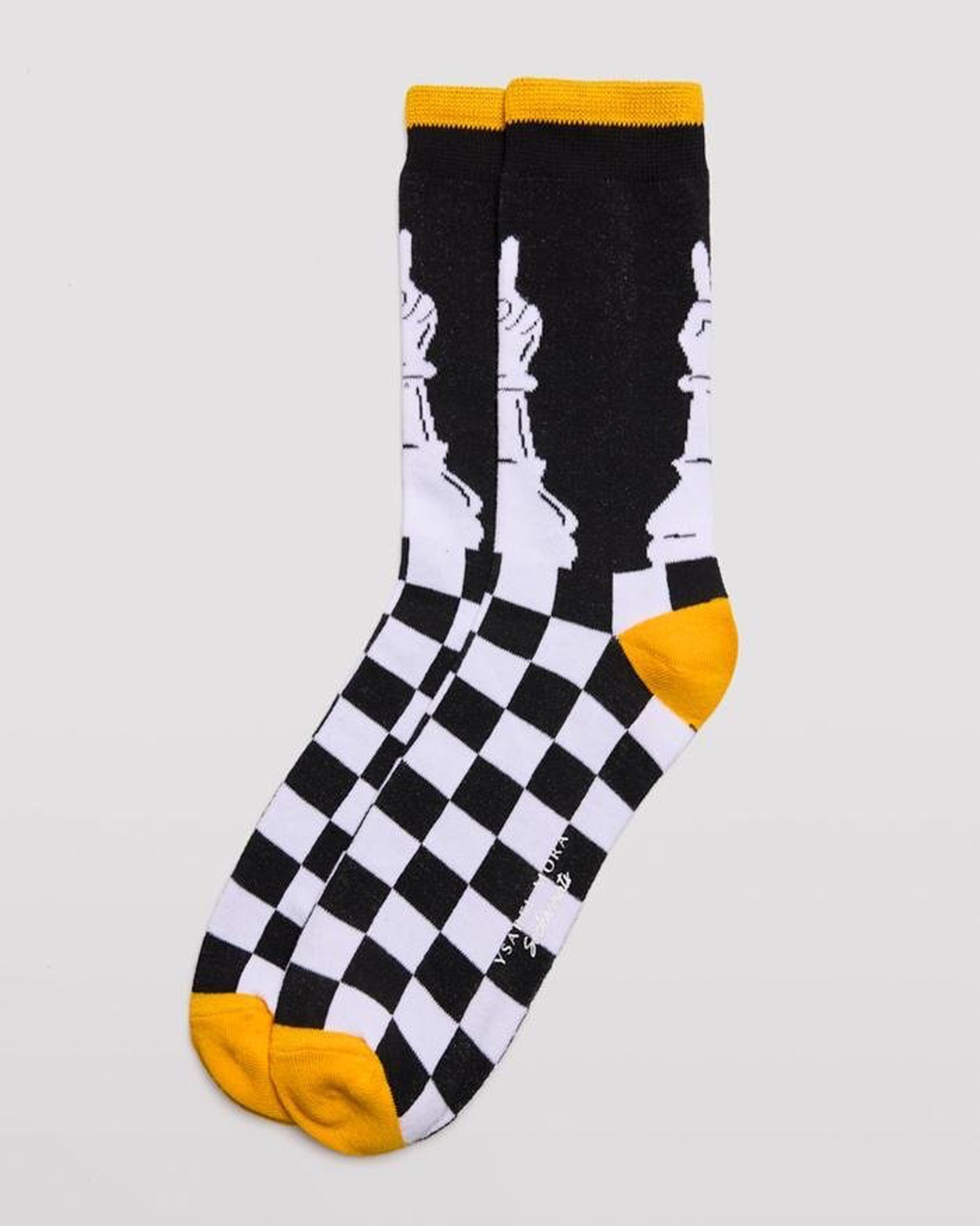 Ysabel Mora 22179 Chess Sock - Men's cotton crew length ankle socks with a chess themed design of a chessboard and pawn piece with a hand on top giving the peace sign, yellow toe and heel and soft anti-pressure cuff with a yellow stripe on edge.