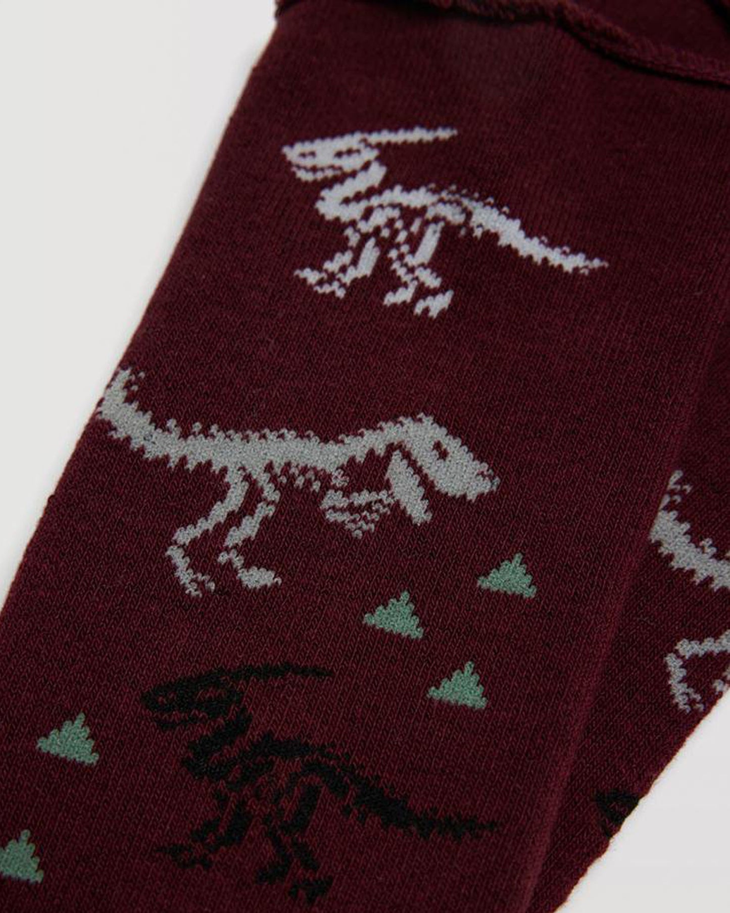 Wine coloured thick and warm terry lined thermal cotton no cuff ankle socks with an all over dinosaur skeleton pattern in light grey, black and white with sage green triangle mountain symbols.