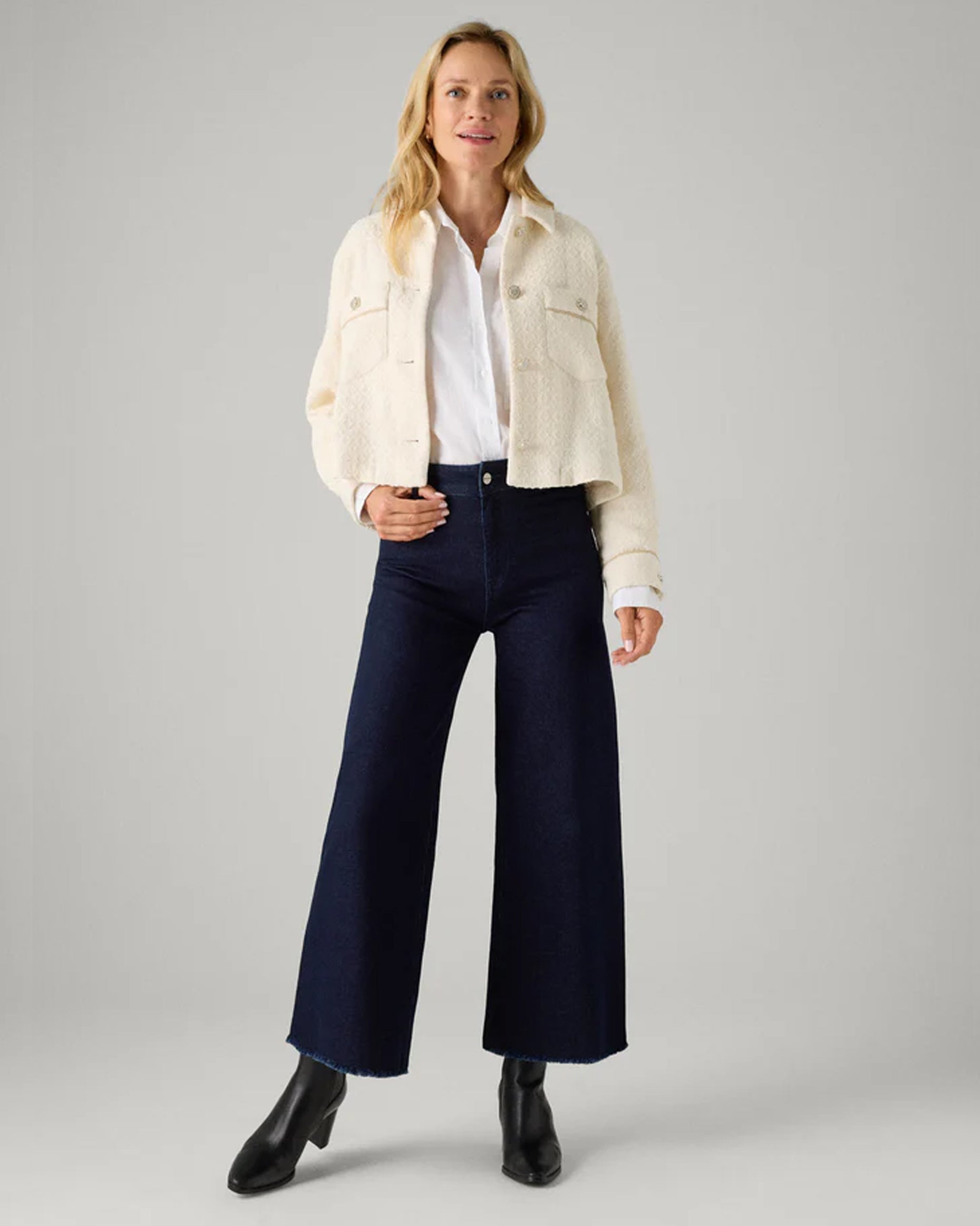 Ysabel Mora 70428 Wide Leg Jeans - Dark denim wide leg high waisted denim jeans with stretch and raw edge. Worn with cropped cream jacket, white shirt and black heeled boots.