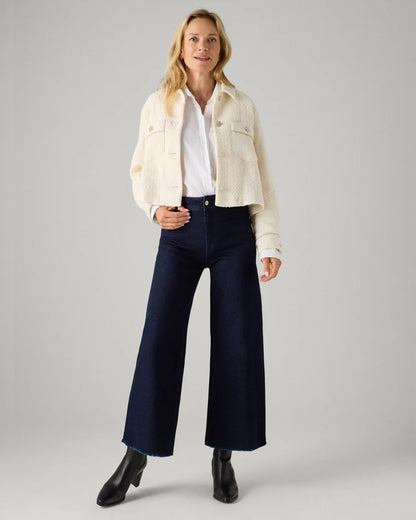 Ysabel Mora 70428 Wide Leg Jeans - Dark denim wide leg high waisted denim jeans with stretch and raw edge. Worn with cropped cream jacket, white shirt and black heeled boots.