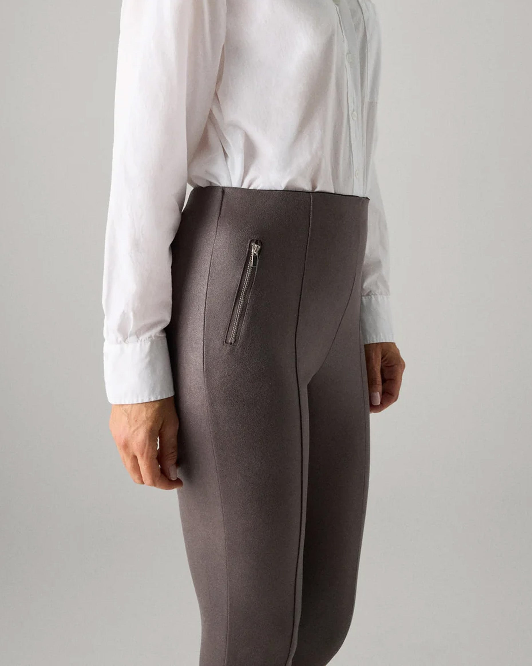 Ysabel Mora 7032 Faux Suede Leggings - Faux suede effect jodhpur style trousers leggings in a grey taupe shade, with silver zipped faux front pockets, front raised seam down the front of the legs, back pockets and taped legs. Side view.