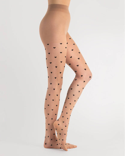 Sheer nude fashion tights with a small black woven heart pattern, invisible reinforced toe and hygienic cotton gusset. Side view.