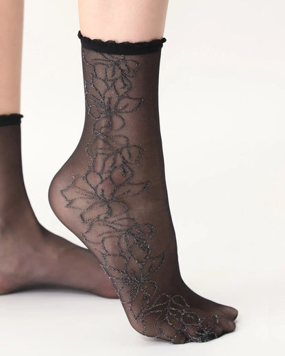 Oroblù Bright Detail Socks - Sheer black fashion ankle socks with a woven floral lace style pattern and scalloped edge elasticated cuff. Side view.